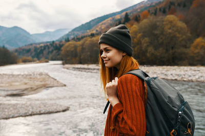 Young woman standing against mountains during winter