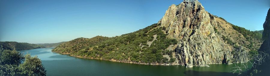 Panoramic view of lake and mountains against clear sky