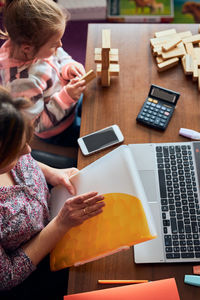 High angle view of people using laptop on table