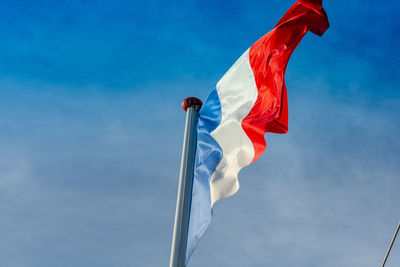 Low angle view of flag against blue sky