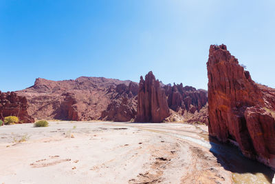 Rock formations in desert against clear blue sky