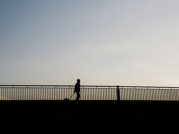 Silhouette people on bridge