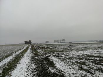 Scenic view of snowy field against sky during winter