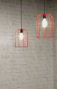 Low angle view of illuminated pendant light hanging on wall
