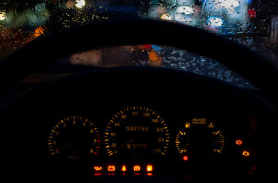 Illuminated ferris wheel seen through car windshield