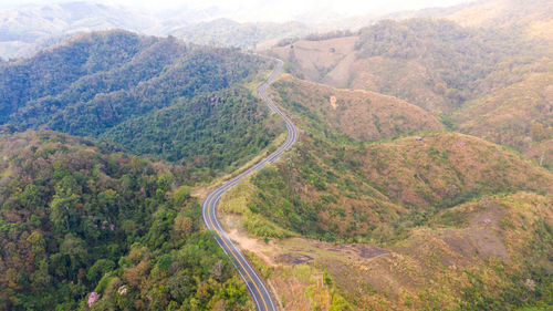 High angle view of road amidst trees and mountains