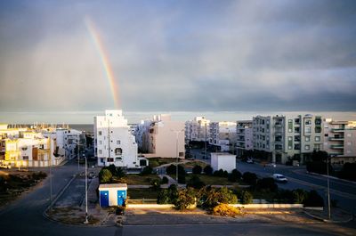 View of rainbow over city buildings