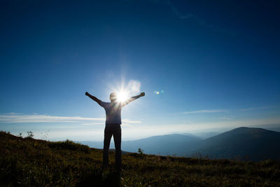 Man standing on field against bright sun