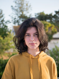 Portrait of teenage girl standing against plants