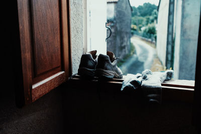 Close-up of shoes and socks on window sill