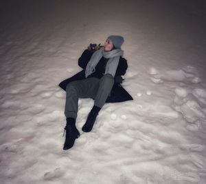 High angle view of man covering face covered with snow