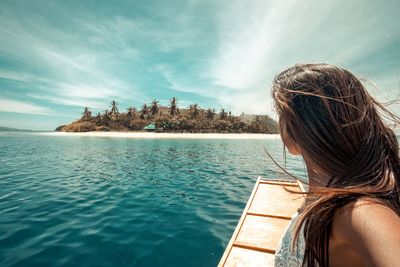 Rear view of woman by sea against sky