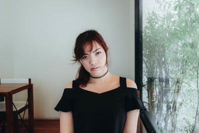 Portrait of woman standing by window