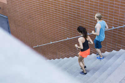 High angle view of fit couple moving down steps