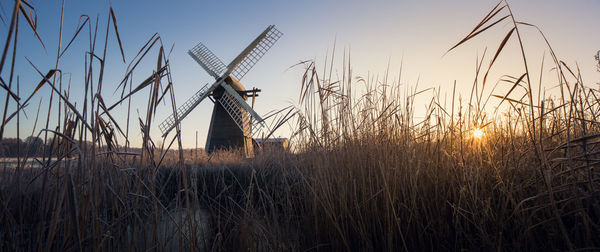 Traditional windmill on field against sky