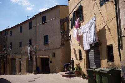 Clothes drying on alley amidst buildings in city