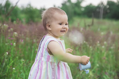 Portrait of cute girl standing against plants