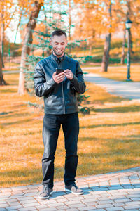 Young man standing on footpath in park