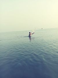 Man surfing in sea against clear sky