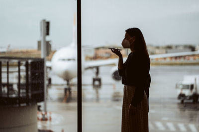 Woman standing by railing against sky