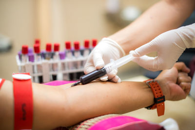 Cropped hands of doctor removing blood sample from patient arm