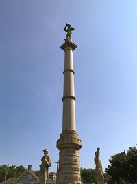 Low angle view of statue against blue sky