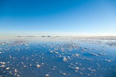 Scenic view of snow covered landscape against clear blue sky