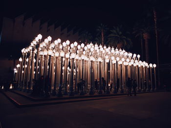 Illuminated lights against trees at night