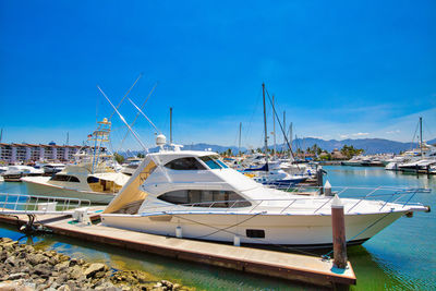 Sailboats moored at harbor