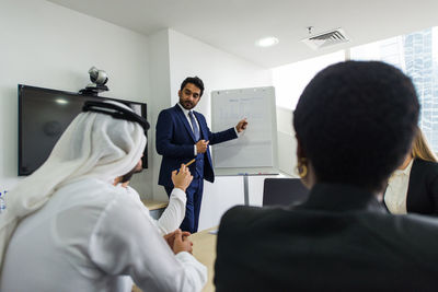 Businessman giving presentation to colleagues in office meeting