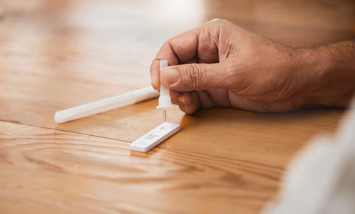 Cropped hand of person holding key on table