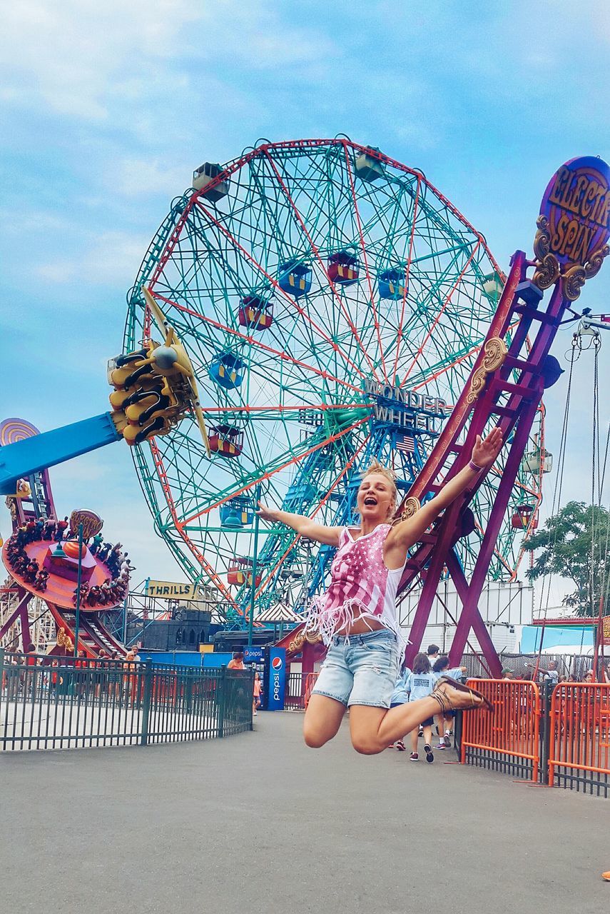 leisure activity, lifestyles, amusement park, sky, arts culture and entertainment, amusement park ride, enjoyment, fun, person, beach, built structure, ferris wheel, full length, architecture, men, standing, cloud - sky, low angle view