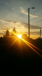 Sunset over silhouette trees against sky
