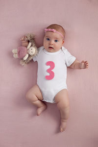 Portrait of cute baby girl sitting on sofa at home