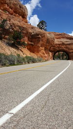 Empty road leading towards tunnel at red rocks canyon