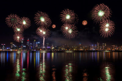 Firework display over river at night