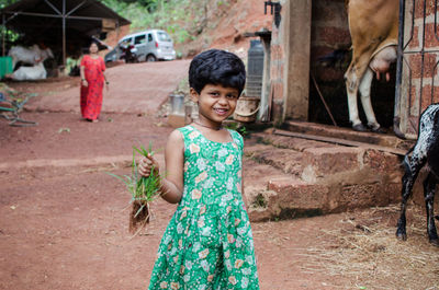 Portrait of smiling girl standing by tree