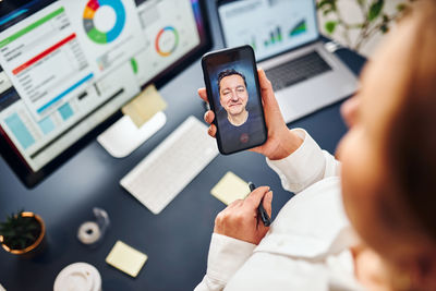 Businesswoman having video call on mobile phone. businesswoman working with data on charts in office