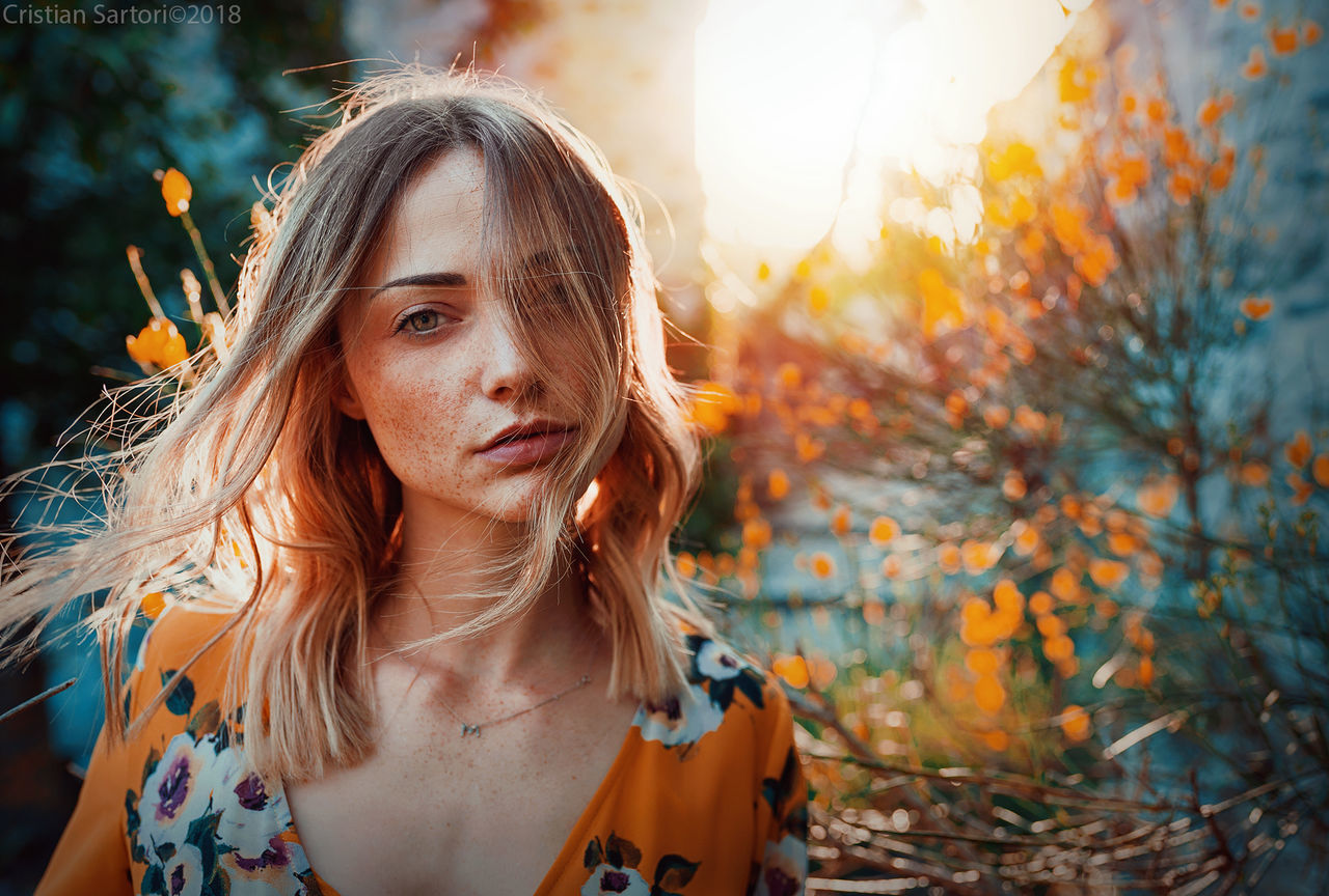 PORTRAIT OF YOUNG WOMAN WITH PLANTS