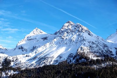 Scenic view of snowcapped mountains against blue sky