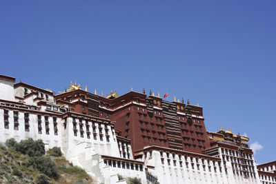 Low angle view of buildings against clear blue sky