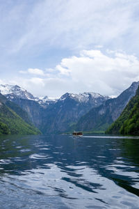 Scenic view of lake by mountains against sky