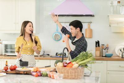 Friends standing on cutting board at home