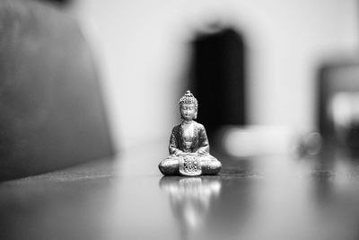 Close-up of small buddha souvenir on table