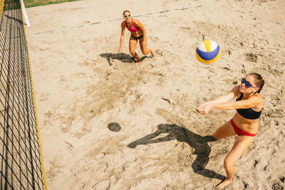 High angle view of friends playing volleyball at beach