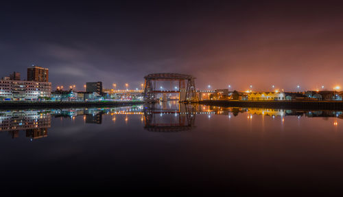 Puente transbordador over matanuska river by illuminated city against sky at night