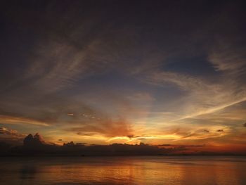 Scenic view of sea against dramatic sky during sunset