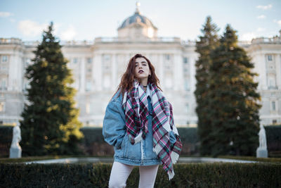 Portrait of woman standing against historic building