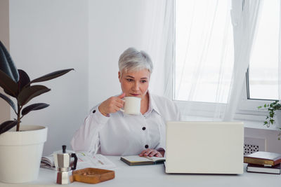 Businesswoman drinking coffee at office
