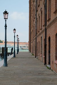 Walkway amidst buildings against sky